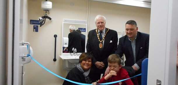 cutting the ribbon to open the changing places facility with people and mayor in the background
