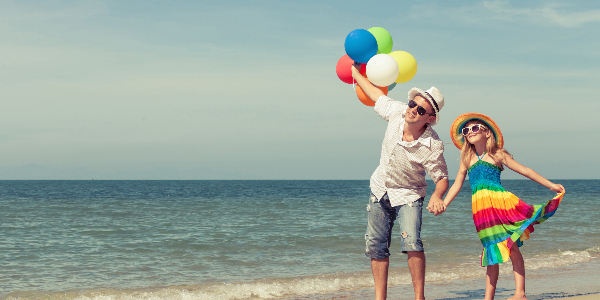 Father walking with his daughter on a beach