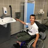Boy in a wheelchair in an accessible toilet