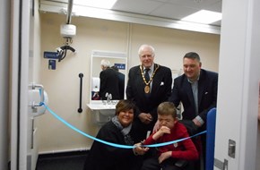 cutting the ribbon to open the changing places facility with people and mayor in the background