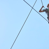 Child smiling on tightrope in harness