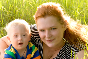 Mother laying with her young child in the grass